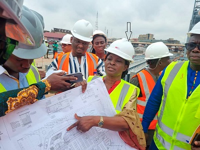 Gifty Ohene Konadu (arrowed) of the Office of the President being taken through the plan of the Kumasi Central Market.